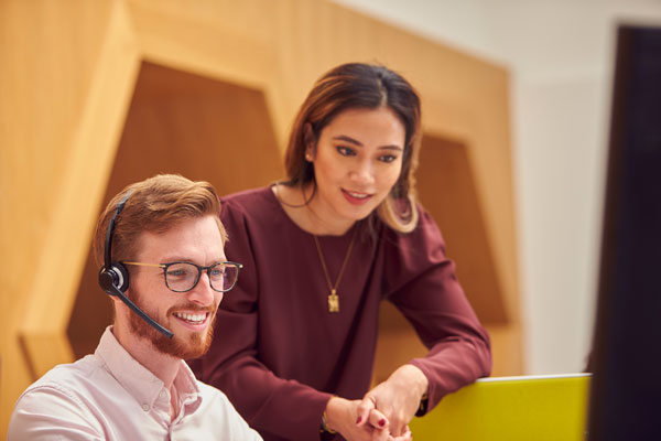 businessman-wearing-headset-talking-to-colleague